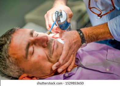 Close Up Of Male Receiving Local Cryotherapy Treatment To Her Face. Nitrogen Vapors Applied.