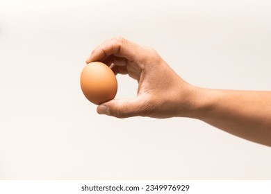 Close up male right hand holding chicken egg for prepare cooking isolate on white background.Hand holding organic produced eggs. - Powered by Shutterstock