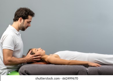 Close Up Of Male Therapist Doing Reiki Therapy On Little Girl Touching Head On Both Sides.