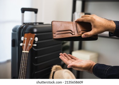 Close Up Male Traveller Hand Open The Empty Wallet Near Trolley Bag In The House.There Is No Money In Wallet. No Budget To Travel