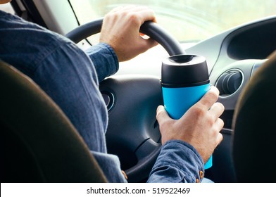 Close Up Of Male's Hand Holding Thermo Mug With Hot Coffee Driving In A Car