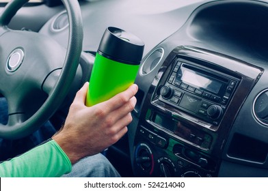 Close Up Of Male's Hand Holding Thermo Mug With Hot Coffee Driving In A Car