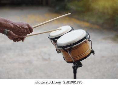 Close up man is beating the bongo drums. Concept, musical percussion instrument for rhythm of music to make more fun for performing or dancing. Beat drum with rhythm along music and songs. 