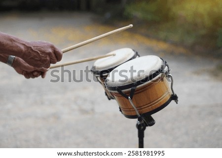Close up man is beating the bongo drums. Concept, musical percussion instrument for rhythm of music to make more fun for performing or dancing. Beat drum with rhythm along music and songs. 