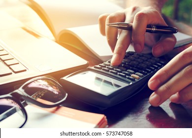 Close up man calculate cost on desk at home.