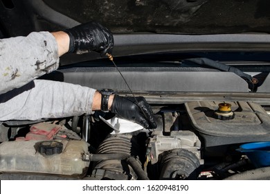 Close Up Of Man Checking The Oil Dipstick During A DIY At Home Oil Change