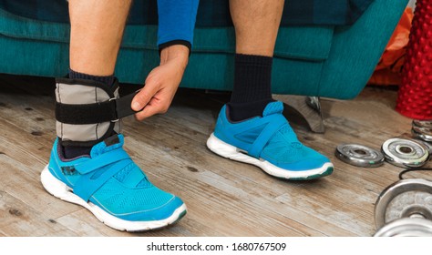 Close Up Of A Man Closing Velcro Strap Of An Ankle Weight During A Home Workout