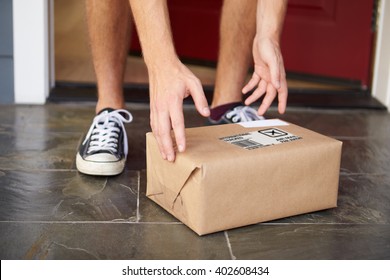 Close Up Of Man Collecting Parcel Delivery Outside Door