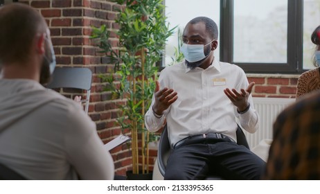 Close Up Of Man Complaining About Alcohol Addiction At Aa Group Meeting During Pandemic. Adult With Face Mask Attending Rehab Therapy Session And Talking About Mental Health Problems.