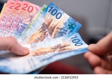 Close up of the man counting swiss francs - Shutterstock ID 2136915953