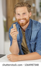 close up of a man eating a cereal bar