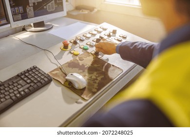 Close Up Of Man Factory Worker Sitting At The Table With Desktop Computer And Turning Key On Control Panel