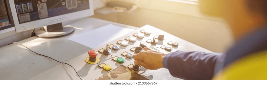 Close Up Of Man Factory Worker Sitting At The Table With Desktop Computer And Turning Key On Control Panel