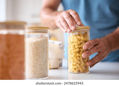 Close Up Of Man Filling Up Storage Jar From Bag In Kitchen At Home - Powered by Shutterstock