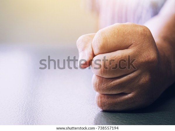 close up\
of a man fists clenched on office desk  in anger with window light\
effected, Vintage color tone. copy\
space