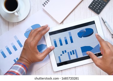 Close up of man hand analyzing chart on digital tablet 