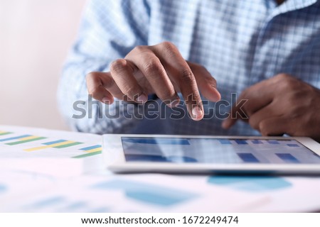 Close up of man hand analyzing chart on digital tablet 