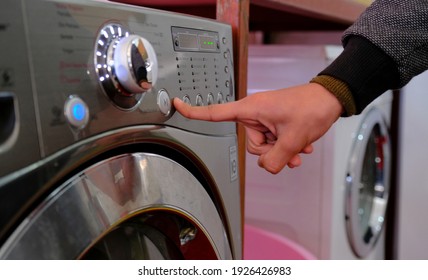 Close up of man hand choosing program for washing machine