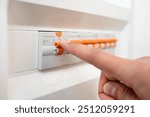 Close up of man hand and electrician with electricity fuse box, check power supply with maintenance on main circuit breaker switch. Engineer, technician and male worker with handyman