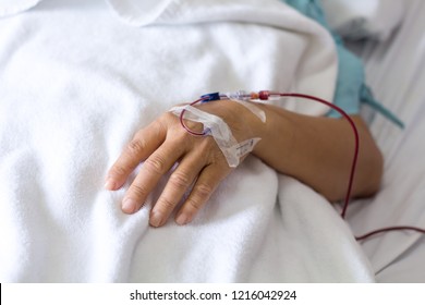 Close Up Man Hand Hold A Patients Hand Who Have A Blood Transfusion In The Hospital With Copy Space Background.