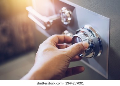 Close up of a man hand hold and tuning on a combinations safe dial lock - Shutterstock ID 1344259001