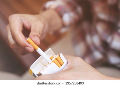 close up man hand holding peel it off cigarette pack prepare smoking a cigarette. Packing line up. photo filters Natural light.