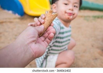 Close up of man hand and little boy hand holding fresh waffle cone, eat ice cream half-cone on baby background,