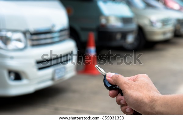 Close up man hand\
presses on the remote control car alarm systems,Auto remote key\
pressed by the finger.