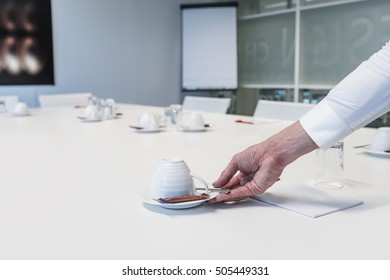 Close Up Of Man Hand Serving Coffee Cup On Table In Corporate Conference Room Before Business Meeting In Office