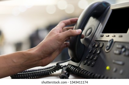 Close Up Man Hand Touching Telephone For Call  Or Connecting With Partner,vendor Or Customer At Computer Desktop Operation Room, Hotline And Helpline Concept.