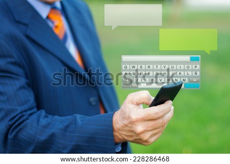 Close up of a man hand typing a message with smartphone, blurred background