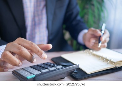 Close up of man hand using calculator  - Shutterstock ID 2012795396