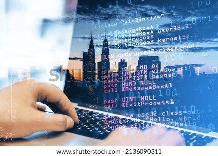 Close up of man hand using laptop keyboard with abstract html code on creative city background. Coding and programming concept. Double exposure