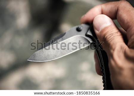 Close up the man hand using stainless steel pocketknife.