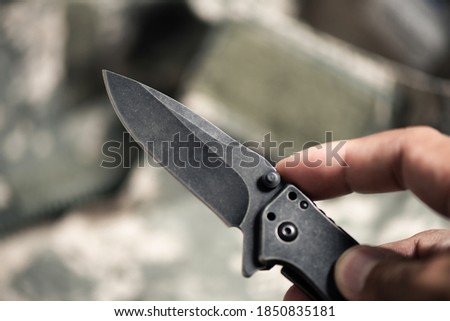 Close up the man hand using stainless steel pocketknife.
