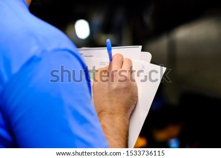 Close up of man hand writing the notes, vote, mark, ideas on paper using ballpoint pen. Exam, interview, training, competition, hospital clinic visit, triage, mark score, studying and learning concept Foto stock © 