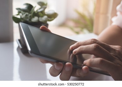 Close Up Of Man Hands Relaxed Using Digital Tablet Computer At Home, Internet Of Things IOT Concept.