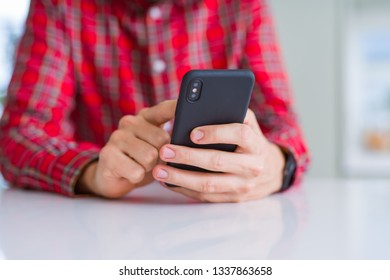 Close up of man hands using smartphone and smiling