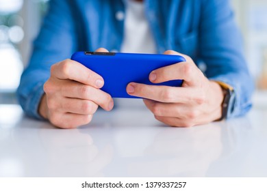 Close up of man hands using smartphone and smiling