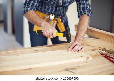 Close Up Of Man Hitting Nail By Hammer 