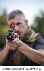 Close up of a man holding an airsoft assault rifle in military uniform