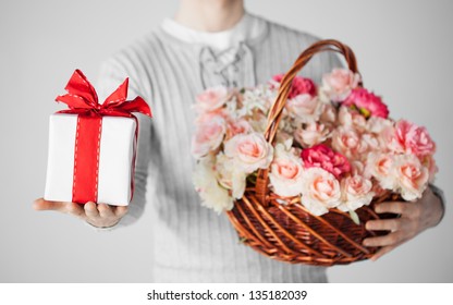 Close Up Of Man Holding Basket Full Of Flowers And Gift Box.