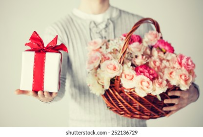 Close Up Of Man Holding Basket Full Of Flowers And Gift Box.