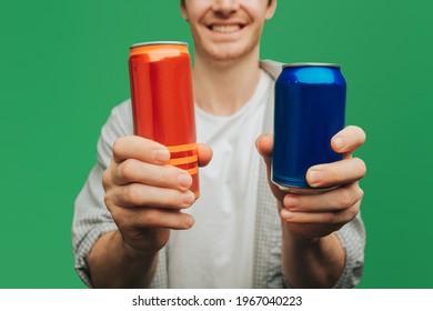 Close up man holds cans, isolated on green background