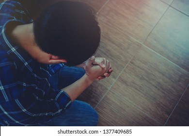 close up of a man knee down on floor and prays to God together indoor, Christian background with copy space.