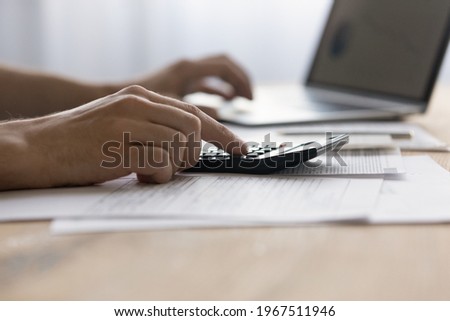 Close up man laptop and calculator, managing finances or planning budget, businessman calculating corporate bills, expenses, browsing online banking service, sitting at table with financial documents