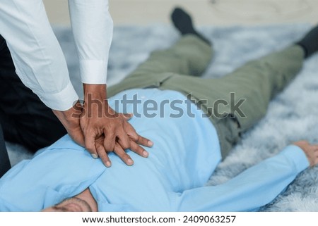 Close up man lying down while another individual, likely a medical professional, is performing a CPR chest compression, potentially in response to heart attack.