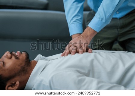 Close up man lying down while another individual, likely a medical professional, is performing a CPR chest compression, potentially in response to heart attack.