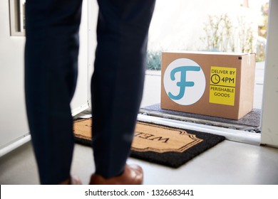 Close Up Of Man Opening Front Door To Fresh Food Home Delivery In Cardboard Box Outside Front Door