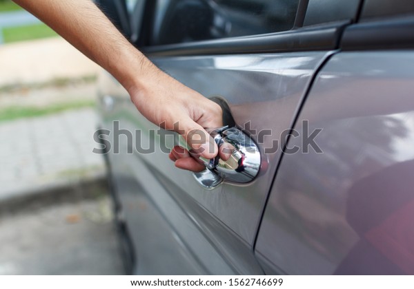 Close up of a man opens\
car\'s door.